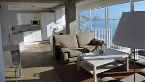 Un salon moderne avec un canapé, une table basse et une vue sur la mer.