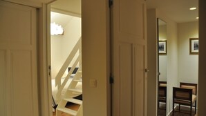 Een gang met een trap die naar een slaapkamer leidt.