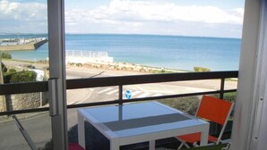 A balcony with a table and chairs, overlooking a coastal road and sea. - Apartment/ flat - Quiberon (Quiberon)