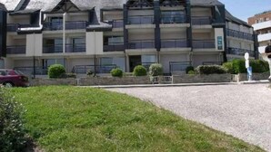 A multi-story hotel with a modern architectural design, featuring balconies and a gravel driveway. - Apartment/ flat - Quiberon (Quiberon)