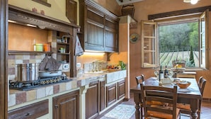 Une cuisine équipée d’une cuisinière, de placards et d’un coin repas avec une table et des chaises.