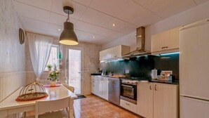 Een moderne keuken met witte kasten, een roestvrijstalen oven en een zwart aanrecht.