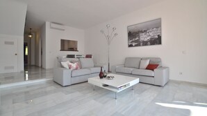 A modern living room with two sofas, a coffee table, and a floor lamp. - House, 3 terraces, directly on golf course, swimming pool, tennis. Close to beach (Nueva Andalucia,)