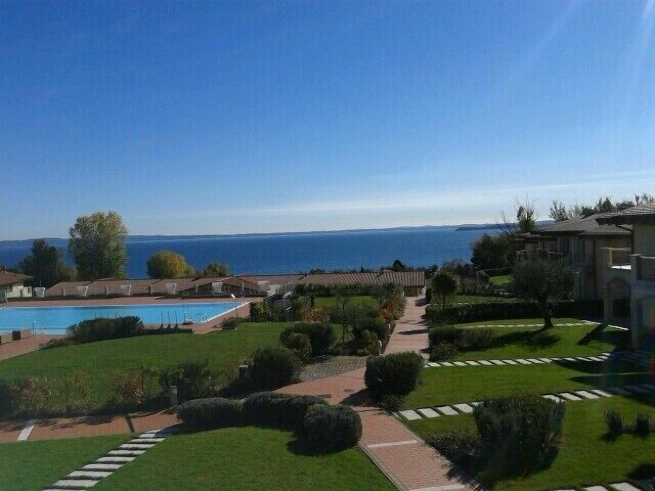 Un complexe hôtelier doté d’une piscine, de pelouses bien entretenues et offrant une vue sur la mer.