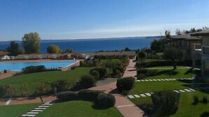 Un complexe hôtelier doté d’une piscine, de pelouses bien entretenues et offrant une vue sur la mer.