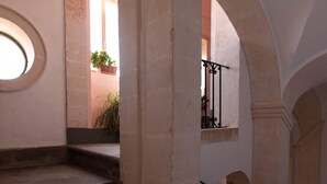 Una escalera de piedra con barandilla de metal que conduce a un nivel superior.