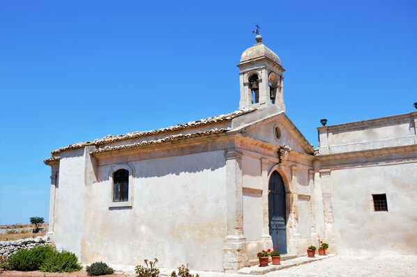A historic building with a bell tower, arched windows, and a tiled roof.