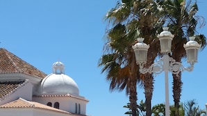A white building with a dome and a bell tower, surrounded by palm trees. - Villa Las Encinas on the Costa del Sol.        (Torrox)