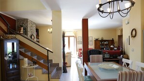 A spacious living area with a staircase, a dining table, and a kitchen area. - Wonderful villa with pool in a panoramic position at the gateway to Cilento. (Ogliastro Cilento)