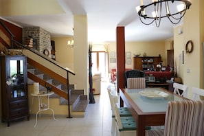 A spacious living area with a staircase, a dining table, and a kitchen area. - Wonderful villa with pool in a panoramic position at the gateway to Cilento. (Ogliastro Cilento)