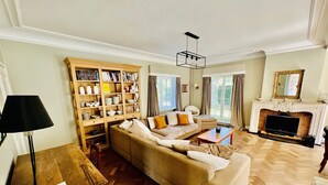 A living room with a sofa, a coffee table, a fireplace, and a bookshelf.