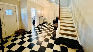 A staircase with a checkered floor leading to a landing.