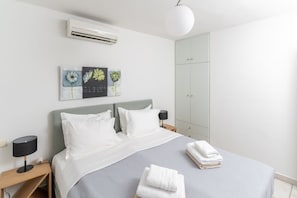 Un dormitorio moderno con cama, mesitas de noche, armario y decoración en la pared.