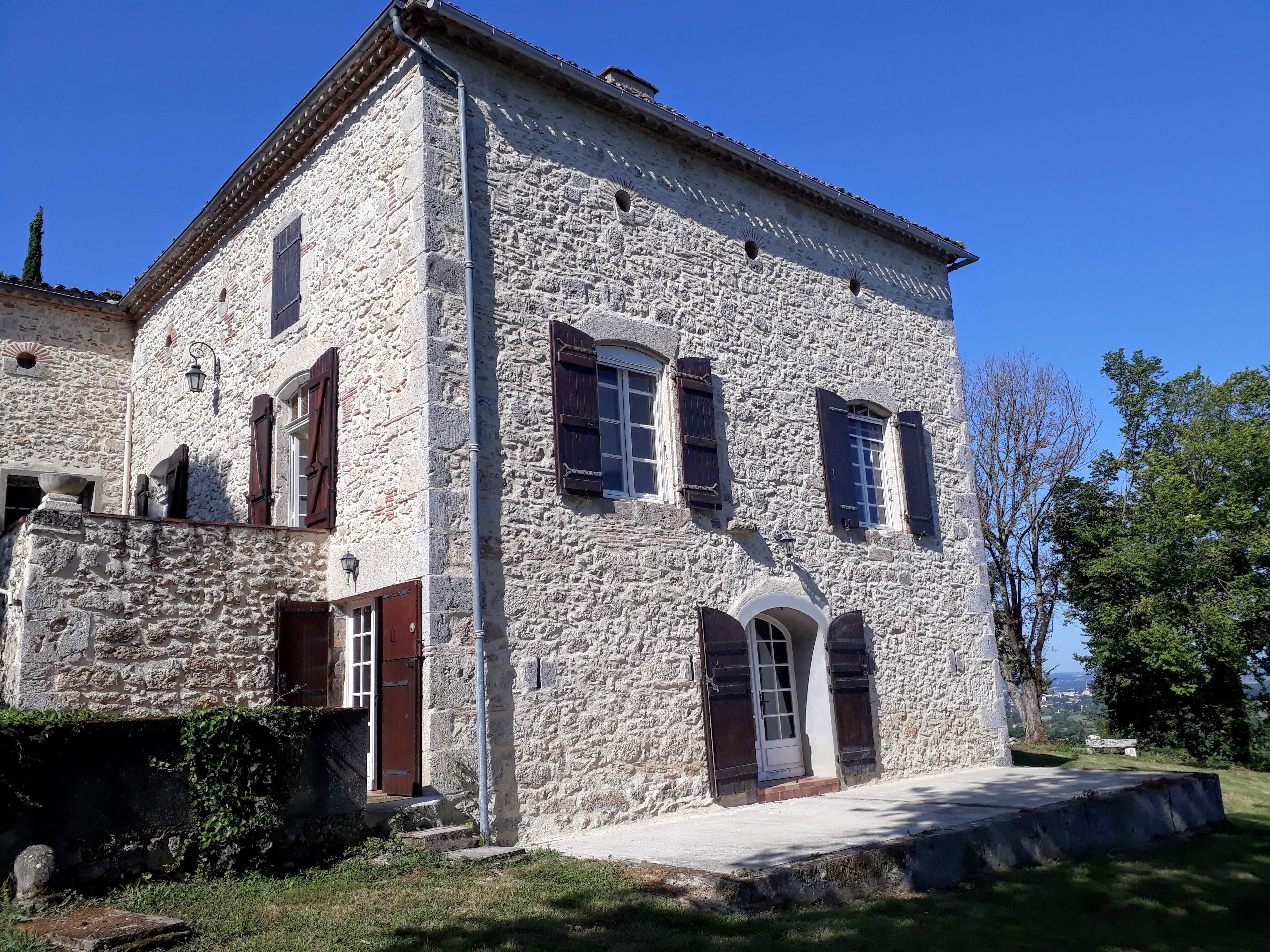 A stone building with a central entrance, two windows on the ground floor, and a small balcony.