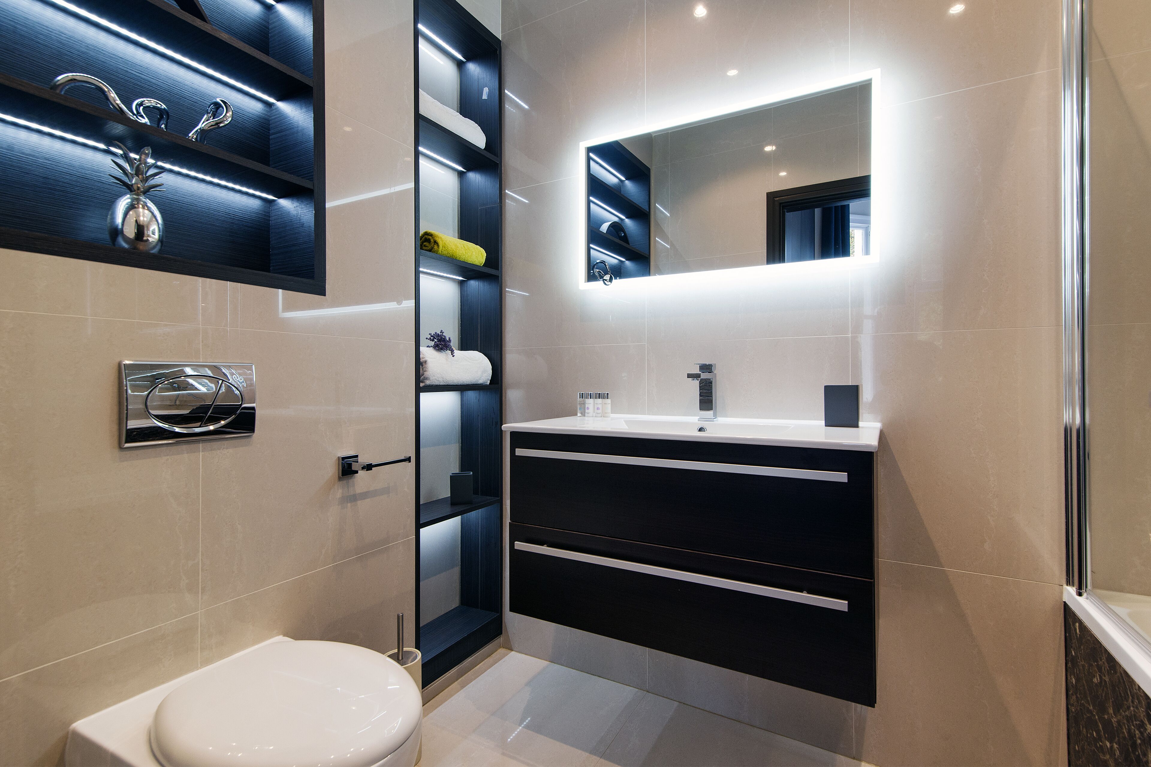 A modern bathroom with a toilet, a sink, a mirror, and shelves with towels and toiletries.