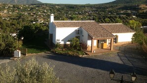 A white building with a tiled roof, surrounded by greenery and a mountainous backdrop. - Finca, Villa, Large HEATED Private Pool fantastic views, secluded near Coin (Coín)