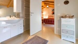 Un baño moderno con un lavamanos, armarios y un perchero.