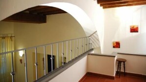 A staircase with a metal railing, a small table, and a painting on the wall. - apartment in Santa Croce 52 in Florence ( Italy) (Firenze)