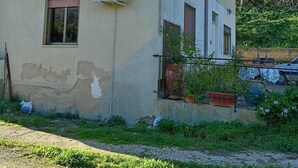 Un immeuble de deux étages doté d’un balcon, de climatiseurs et d’une fenêtre avec des volets.