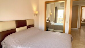 A large bed with a quilted headboard in a hotel room. - City center, air-conditioned apartment in secure residence with swimming pool. (Marrakech)