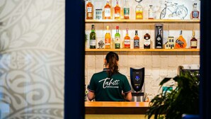 A bar area with shelves of liquor bottles and a coffee machine.
