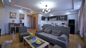 A modern living room with a sofa, coffee table, and a dining area.