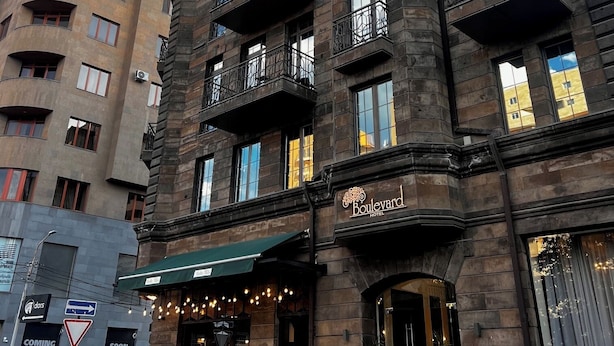 A hotel with a stone facade, multiple balconies, and a sign indicating it is the Boulevard Hotel. - Boulevard Hotel (Yerevan)