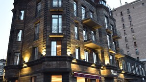 A multi-story building with a corner entrance, large windows, and outdoor seating. - Boulevard Hotel (Yerevan)