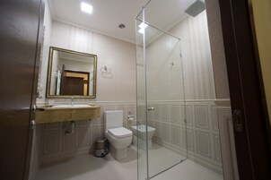 Een badkamer met toilet, bidet en een douchecabine.