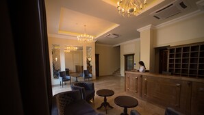 A lobby with a reception desk, seating area, and a chandelier. - Boulevard Hotel (Yerevan)