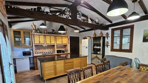 Una cocina amplia con armarios de madera, una mesa de comedor y un horno empotrado.