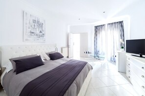 A modern bedroom with a large bed, a flat-screen TV, and a cityscape artwork on the wall. - CENTER ROMA VENETO EXCLUSIVE SUITE APARTMENT (Roma)