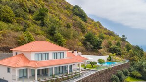 A modern house with a red roof, large windows, and a swimming pool. - Sea View, Luxury, Comfort, Privacy, Free Wifi and Heated Pool (Arco da Calheta)