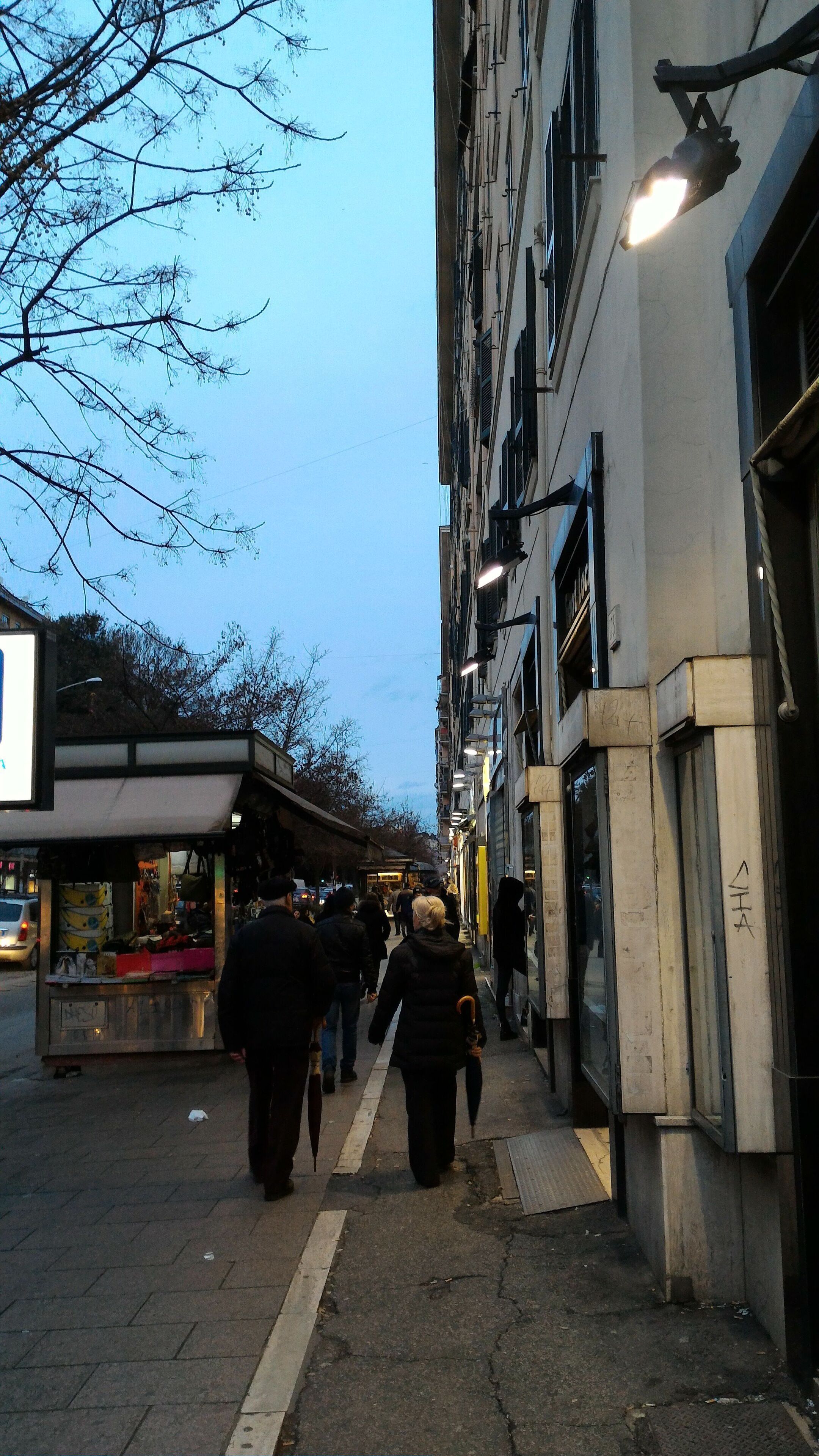 Een smalle stadstraat met voetgangers.