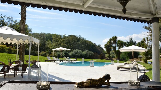A poolside area with lounge chairs, umbrellas, and a statue. - Magic luxury villa, swimming pool, SPA, tennis, wooded park. (Valmontone)