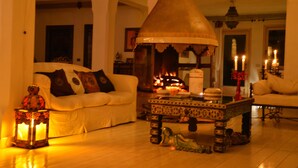 A cozy living room with a fireplace, a white sofa, and a decorative table. - Magic luxury villa, swimming pool, SPA, tennis, wooded park. (Valmontone)