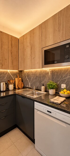 Eine moderne Küche mit Holzschränken, einer eingebauten Mikrowelle, einem Geschirrspüler und einer Marmor-Spritzschutzwand.