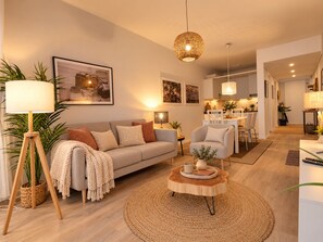 Un salon moderne comprenant un canapé, une table basse et un coin repas avec des chaises et une table.