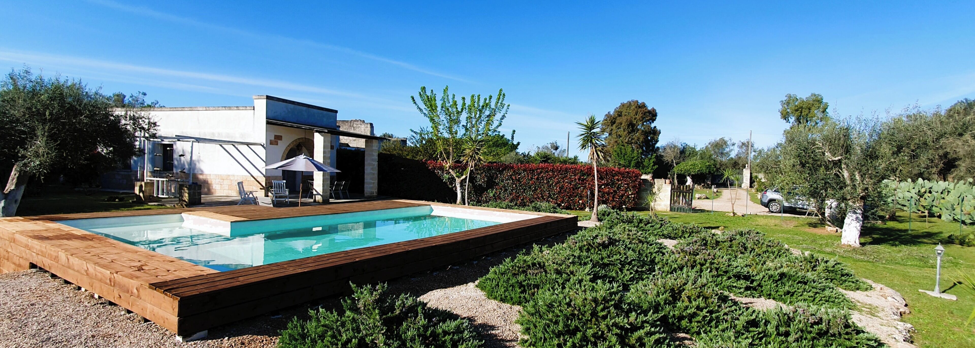 Et moderne hus med swimmingpool, havemøbler og en velholdt have.