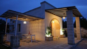 A modern outdoor patio area with a pergola, a table with chairs, and potted plants. - HOUSE WITH GARDEN AND SWIMMING POOL FOR EXCLUSIVE USE IN SALENTO, OTRANTO, LECCE (corigliano d' otranto)
