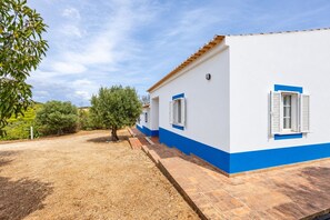 A two-story house with a tiled roof and a small garden area. - Spacious Algarvian Farmhouse with pool set in 5 acres of grounds. 7509/AL (Burgau/Budens)