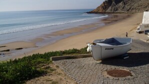 Ein Strand mit einem Boot mit der Aufschrift D592PM am Ufer.
