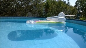 Ein klares, blaues Schwimmbecken mit einer schwimmenden Luftmatratze und einem Liegestuhl.