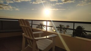 A balcony with a view of the sunset over the sea, a chair, and a glass of wine. - Marina Sol Penthouse <br>- Sea view - Free Wifi (Madalena do Mar)
