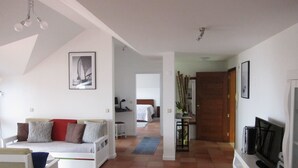 A spacious living area with a sofa, a television, and a framed picture on the wall. - Marina Sol Penthouse <br>- Sea view - Free Wifi (Madalena do Mar)