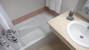 Une salle de bain avec une baignoire, un lavabo et un porte-serviettes.