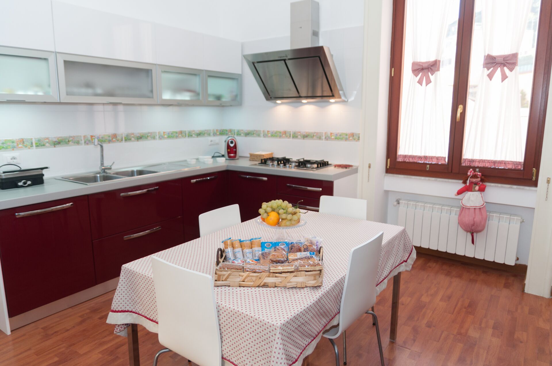 Une cuisine compacte avec un coin repas, comprenant une cuisinière à gaz, un four à micro-ondes et une fenêtre avec des rideaux.