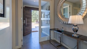 A modern bathroom with a large mirror, a console table, and a door leading to a balcony. - Es Garrover Es Velar with XXL pool, playground, volleyball, billiards, gym.. (Muro)