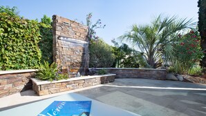 A courtyard with a stone wall, a water feature, and a variety of plants. - Holiday home, Ile d'Oléron 'L'Eglade' 4 star rating * * * * (Le Grand-Village-Plage)