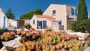A stone building with a tiled roof, a small garden with succulents, and a tall tree. - Holiday home, Ile d'Oléron 'L'Eglade' 4 star rating * * * * (Le Grand-Village-Plage)